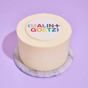 Corporate White Iced Cake with Logo featuring smooth white icing and a colorful edible logo plaque on top.